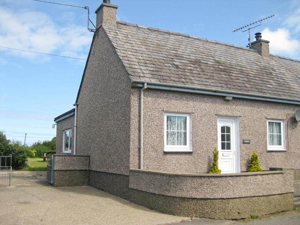 a brick house with a white door at Salfur in Rhiw