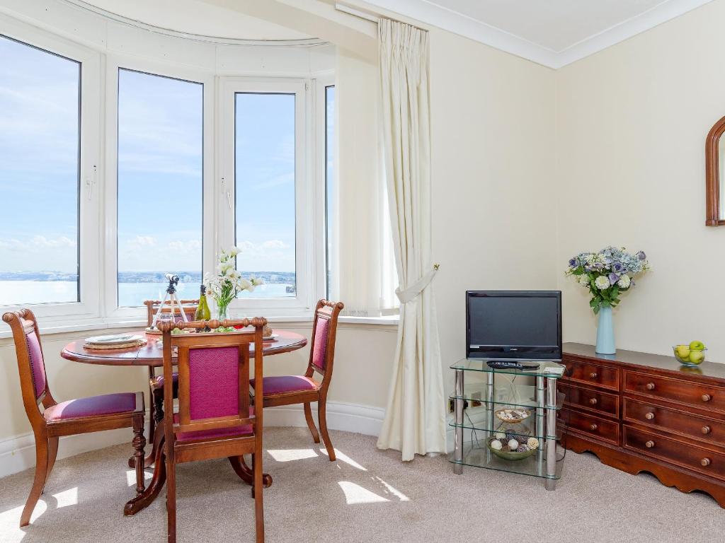 a dining room with a table and a television at Cockington Bay Fort in Torquay