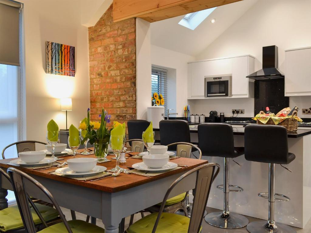 una cucina e una sala da pranzo con tavolo e sedie di Bluebell Barn a Dunnington