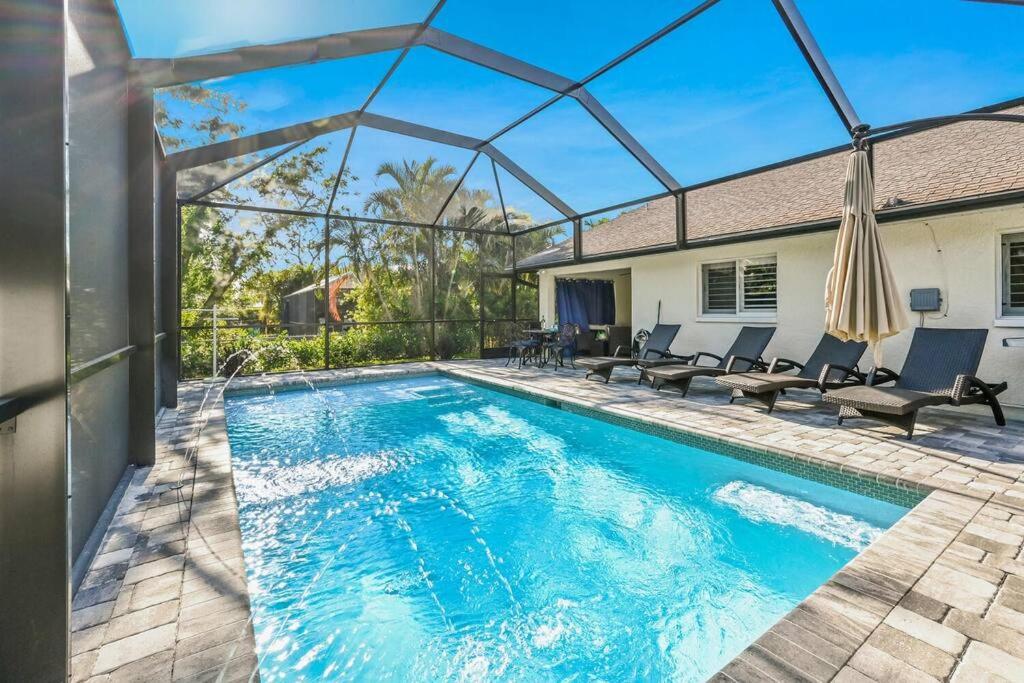 a swimming pool with a patio and a house at Casa Del Mare at the Beach 2 bd rms W King Beds in Naples