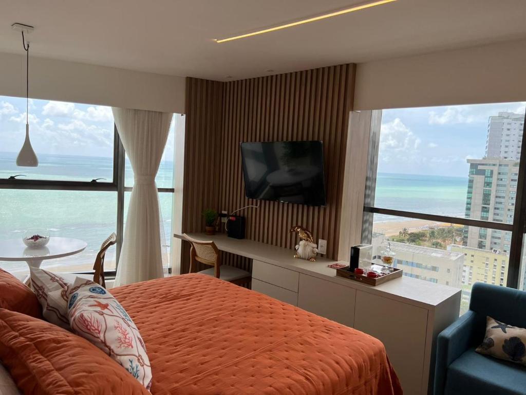 a bedroom with a bed and a view of the ocean at Flat Beira Mar Boa Viagem- Beach Class Internacional in Recife