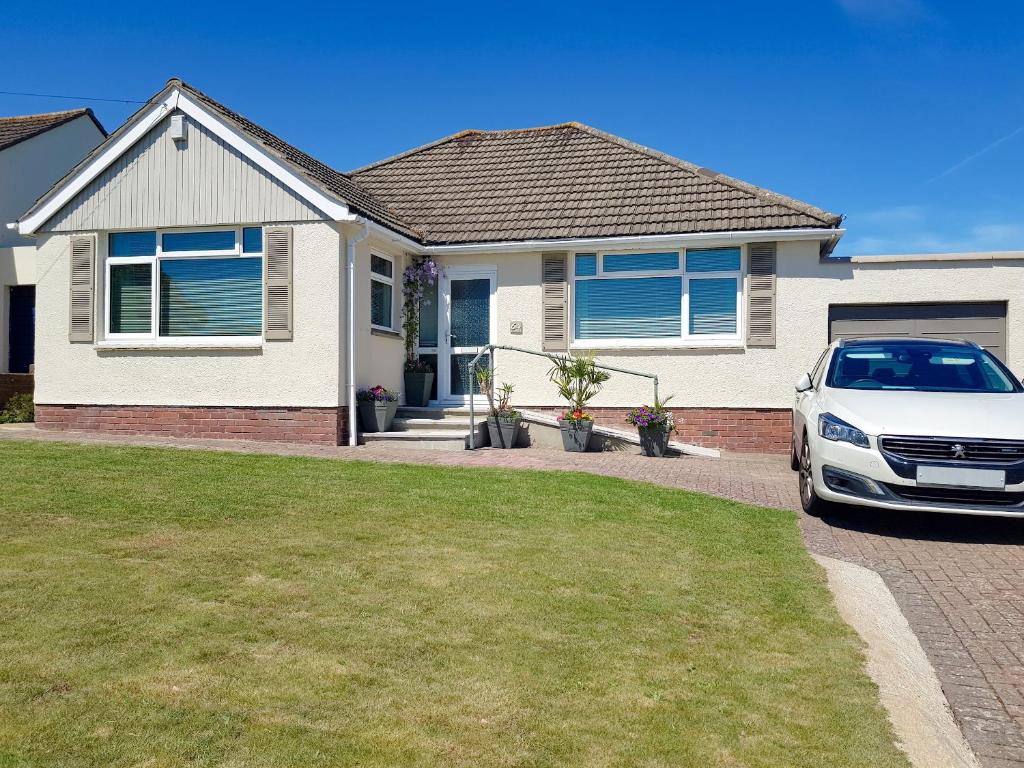 een witte auto geparkeerd voor een huis bij Sandringham Heights in Paignton