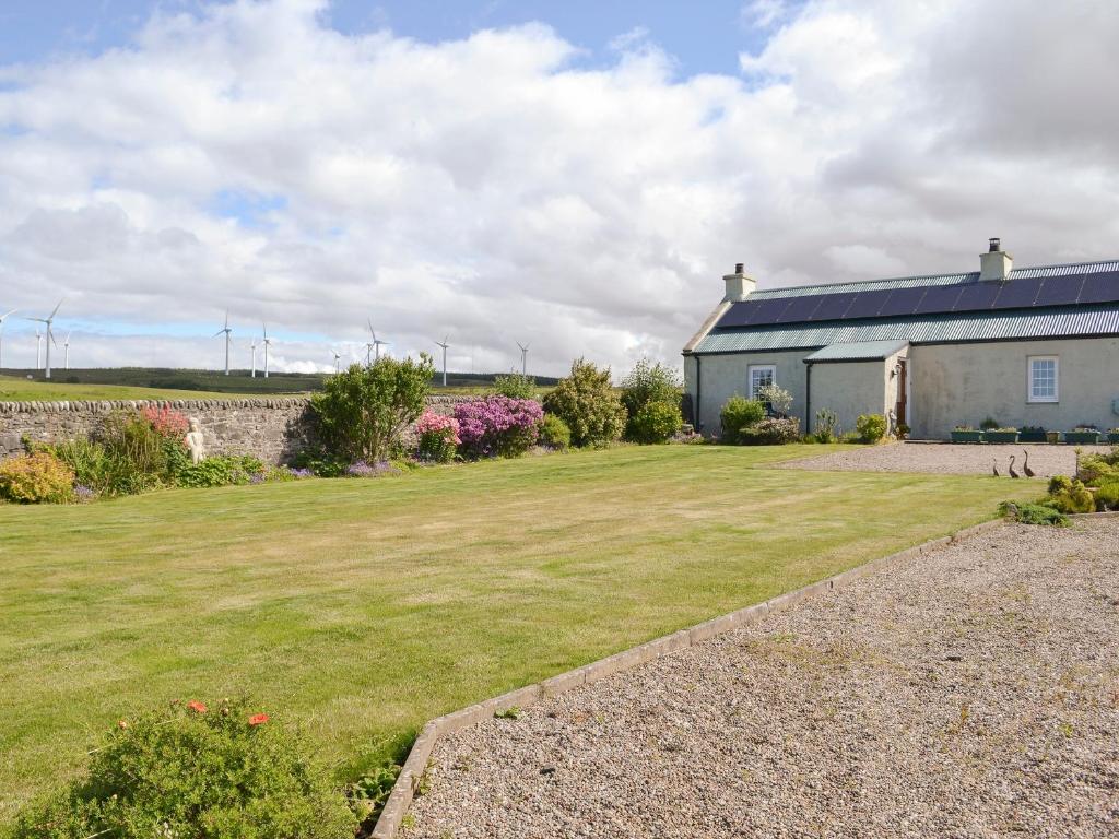 a house with a large yard next to a building at Hazels Cottage in Kilchenzie