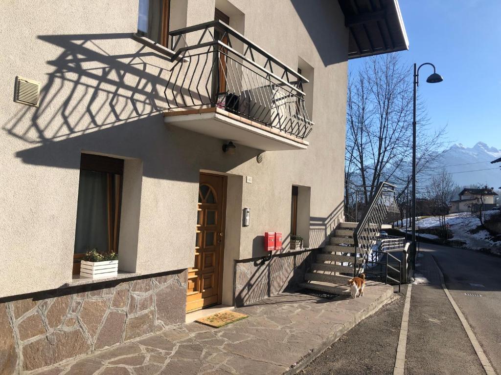 a dog sitting on the side of a building with a balcony at Appartamento Elisa in Taibon