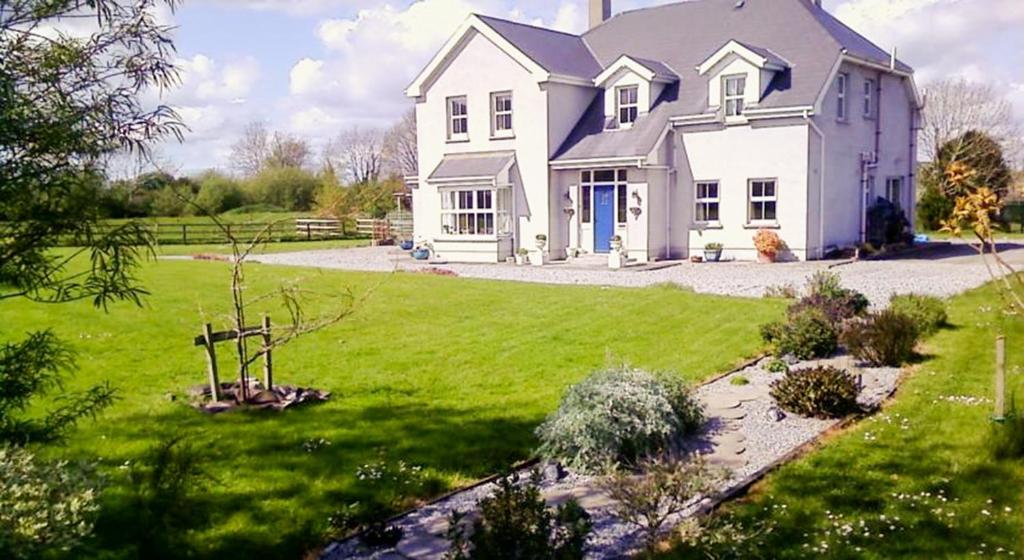 a large white house with a green yard at The Well Meadow B&B in Nenagh