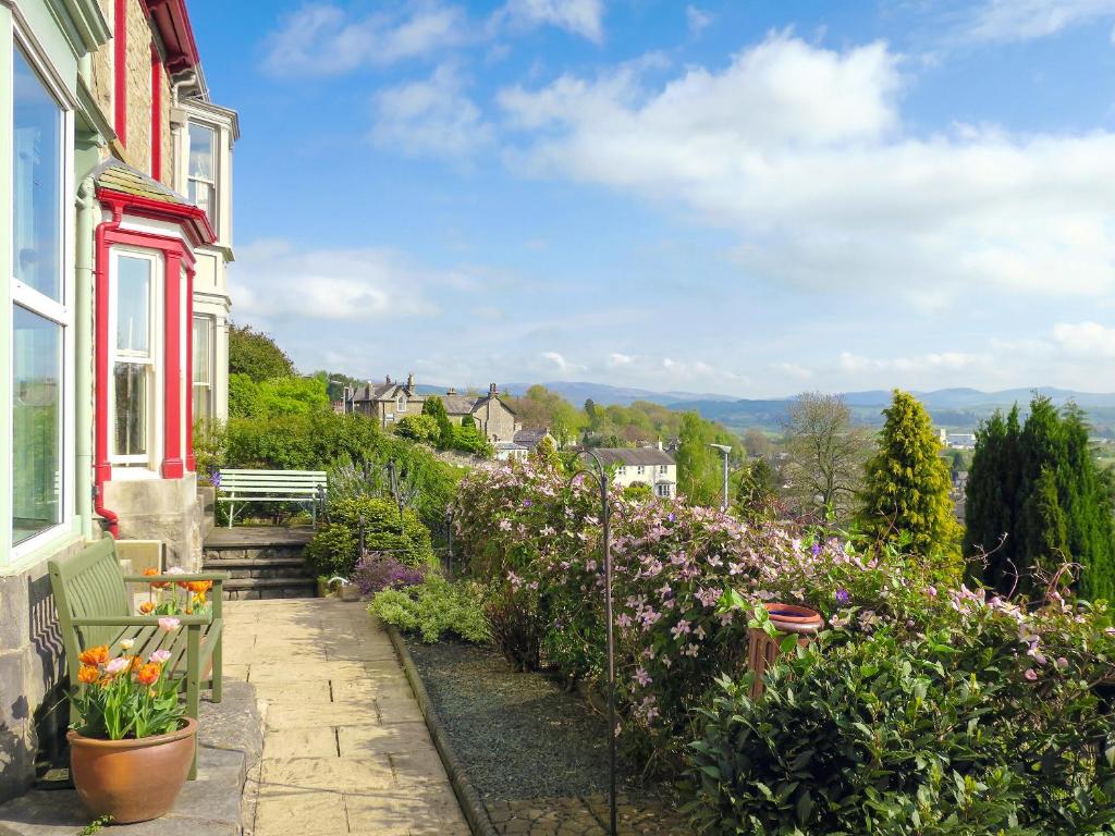 a garden with flowers on the side of a house at Beech Hill in Burneside