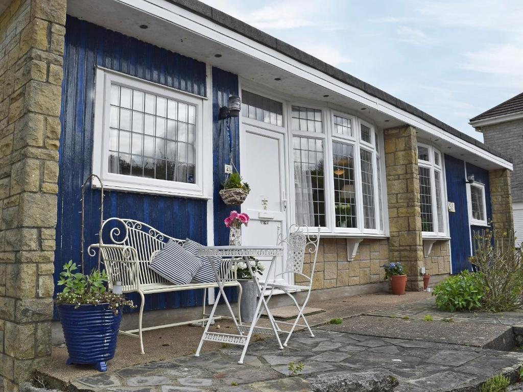 a blue house with two chairs in front of it at Bracelet Cottage in The Mumbles