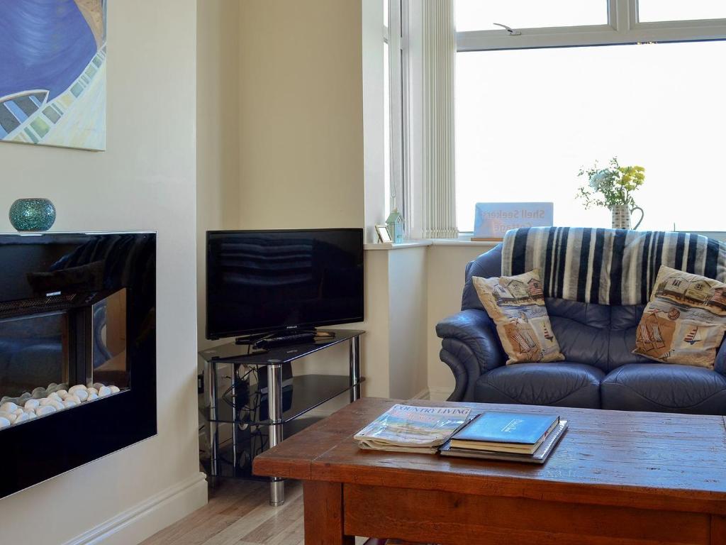 a living room with a couch and a coffee table at Shell Seekers Cottage in Hornsea
