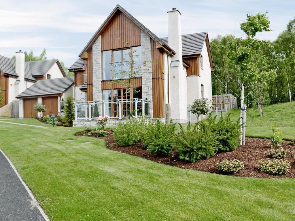 a house with a lawn in front of it at Lochnagar Lodge in Aviemore