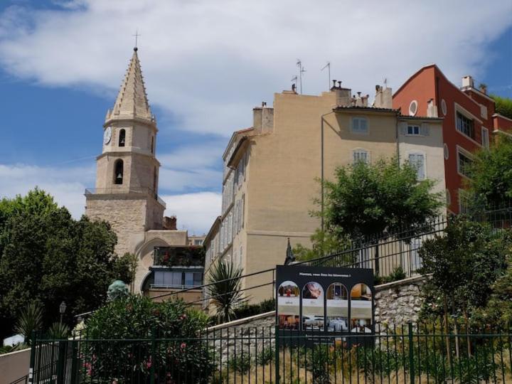 a building with a tower and a church with a steeple at VIEUX PORT in Marseille