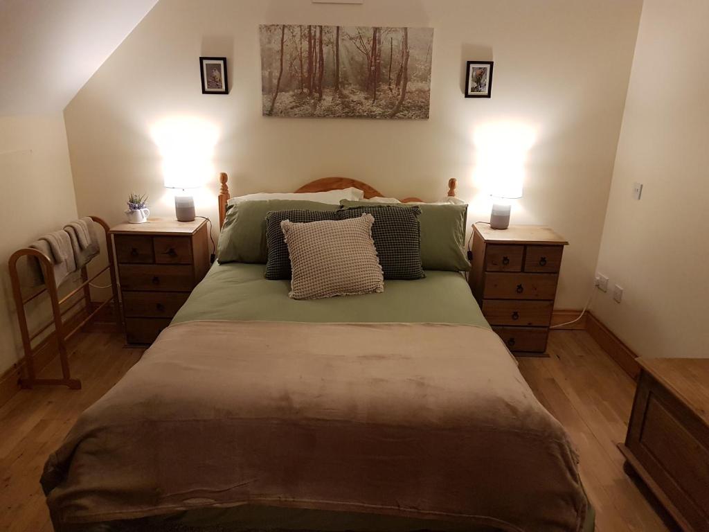 a bedroom with a large bed with two night stands at Little Meadow 