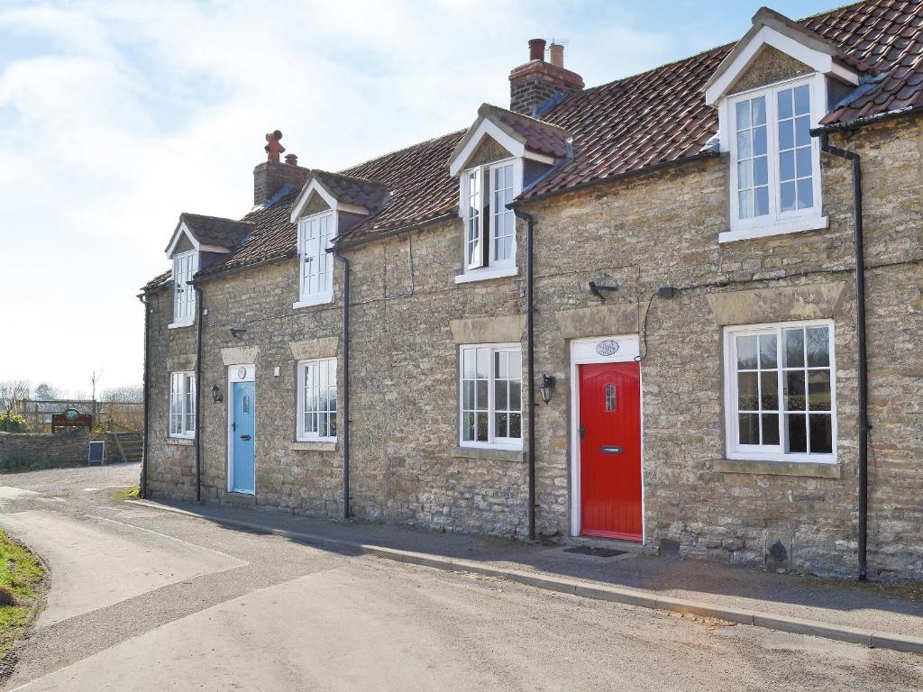 a row of brick houses with red and blue doors at Gunluk Cottage in Brompton