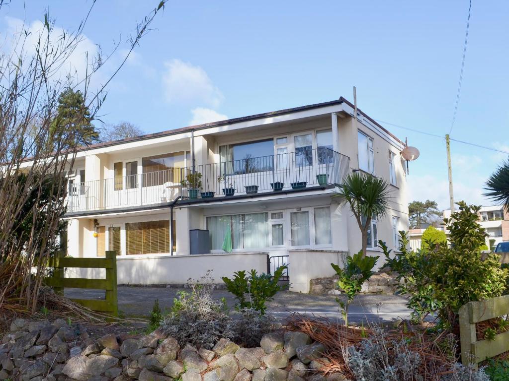 a white house with a fence in front of it at Flat F1 in Dawlish Warren