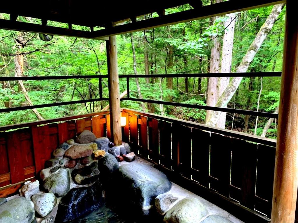 a porch of a cabin with rocks and trees at Setsugetsuka - Vacation STAY 34181v in Nikko