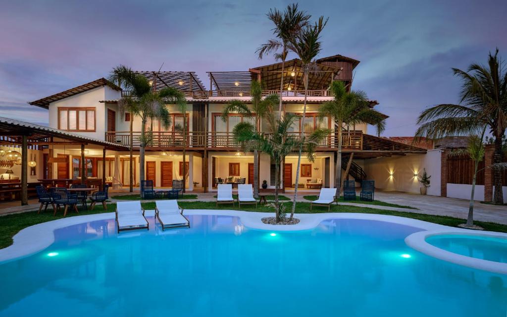 a villa with a swimming pool and a house at Pousada Casa Zê - Praia do Preá in Prea