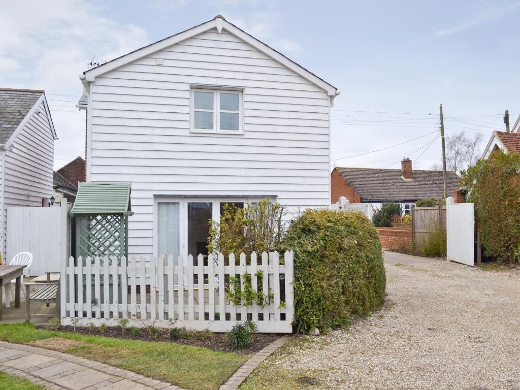 a white house with a white picket fence at Baytree Cottage 2 in Birch