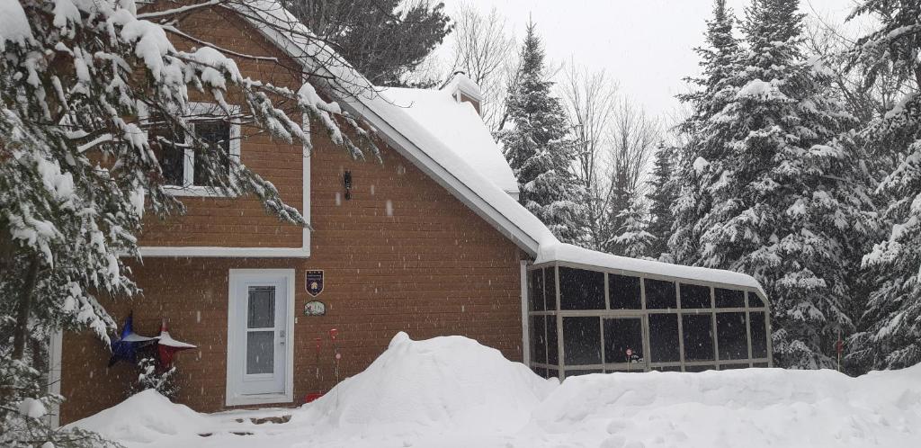 a house covered in snow in front at Chalet chez Antoine in Saint-Donat-de-Montcalm