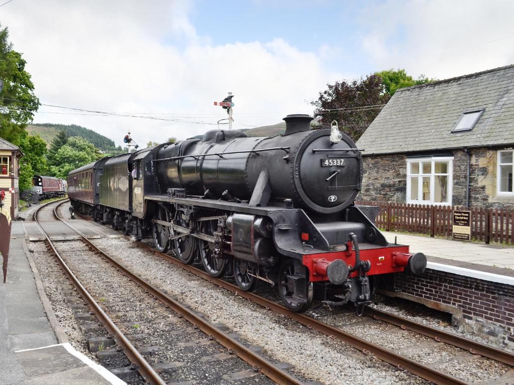 a train is sitting on the tracks at Porters Lodge in Glyn-Dyfrdwy