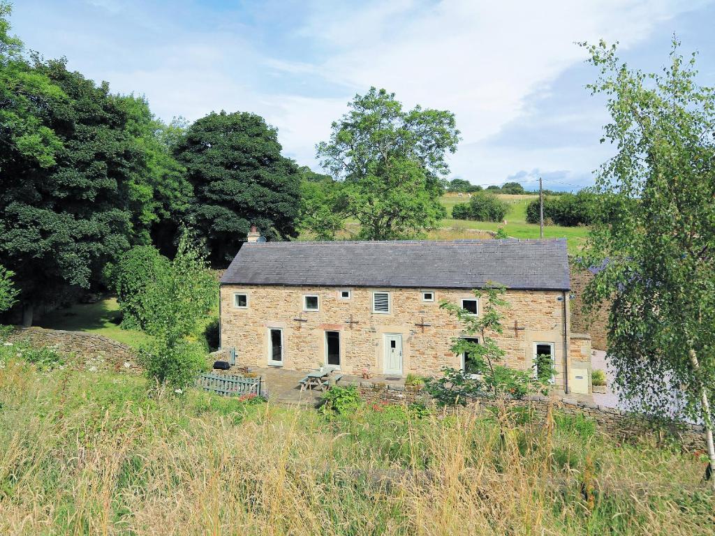 an old stone house in the middle of a field at West Barn in Chesterfield