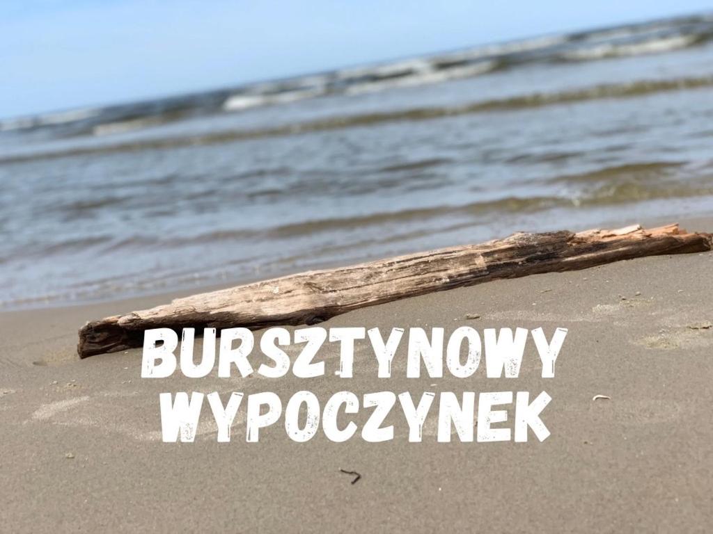 a sign on a beach with the words brunswickifyomyromyk at Bursztynowy Wypoczynek in Jantar