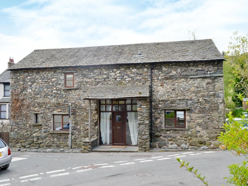 an old stone house on the side of a street at Beck Edge in Braithwaite