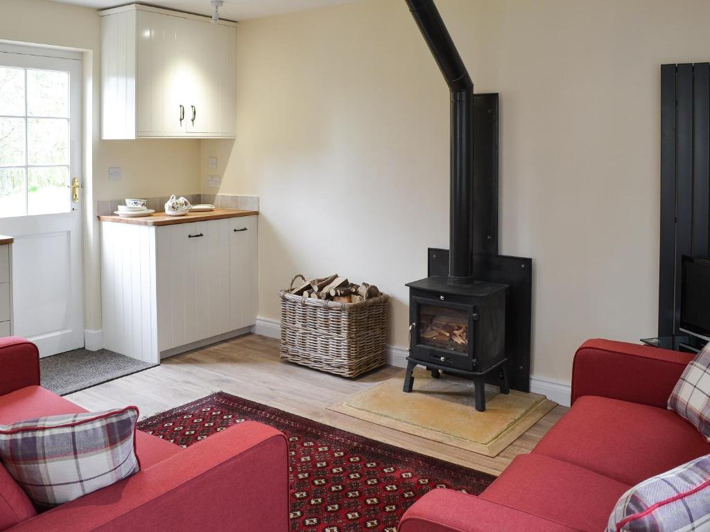 cocina y sala de estar con fogones en Holly Cottage, en Long Houghton