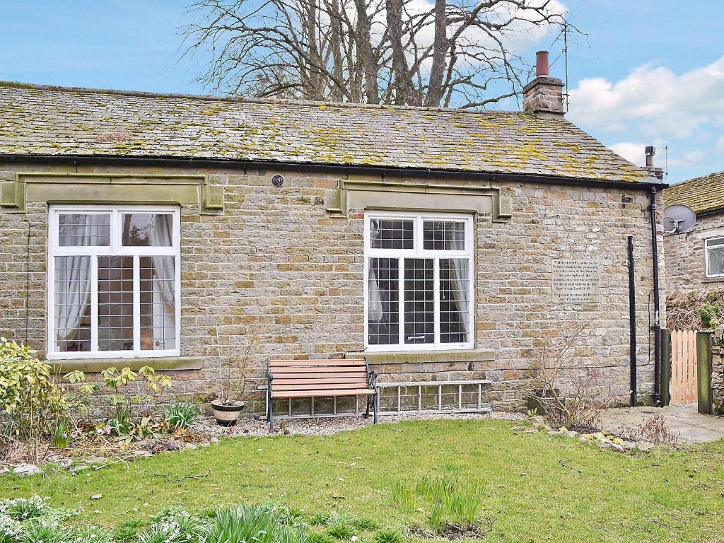 a brick house with a bench in front of it at The School House - 28445 in Middleton in Teesdale