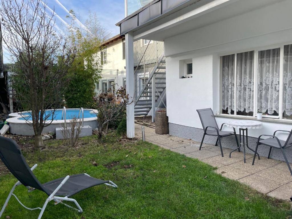 patio con sillas, mesa y bañera en Cheap Outlet Center Apartment with Pool, en Parndorf