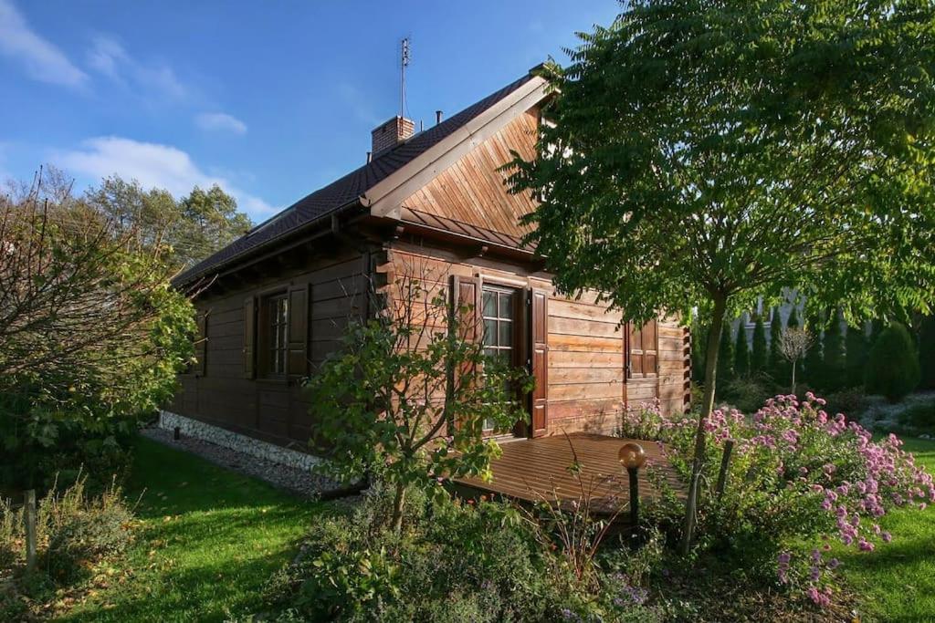 una casa de madera con un jardín delante de ella en Nad Bystrą en Nałęczów