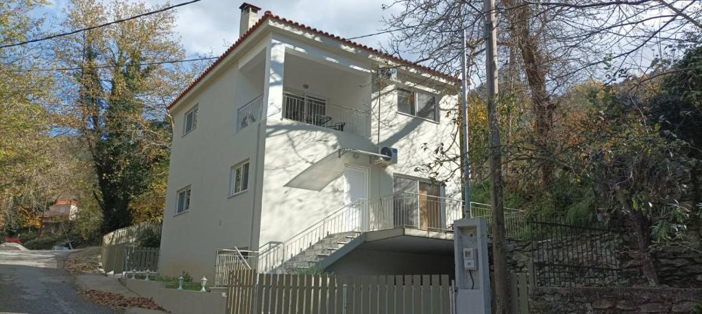 a white building with a balcony and a fence at Villa Eva 2 