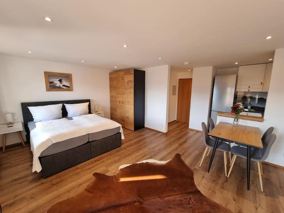 Schlafzimmer mit einem Bett, einem Schreibtisch und einem Tisch in der Unterkunft Phils Apartment in Rettenberg