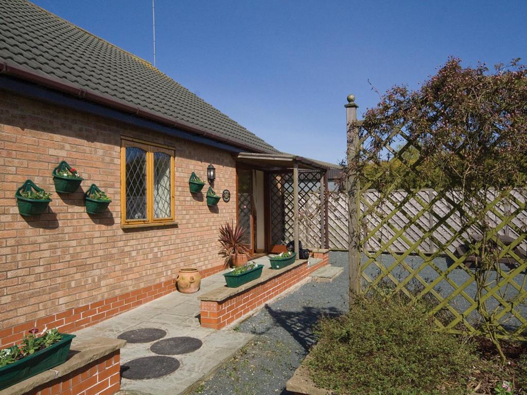 a brick house with potted plants on the side of it at Beech Cottage - E4779 in Atwick