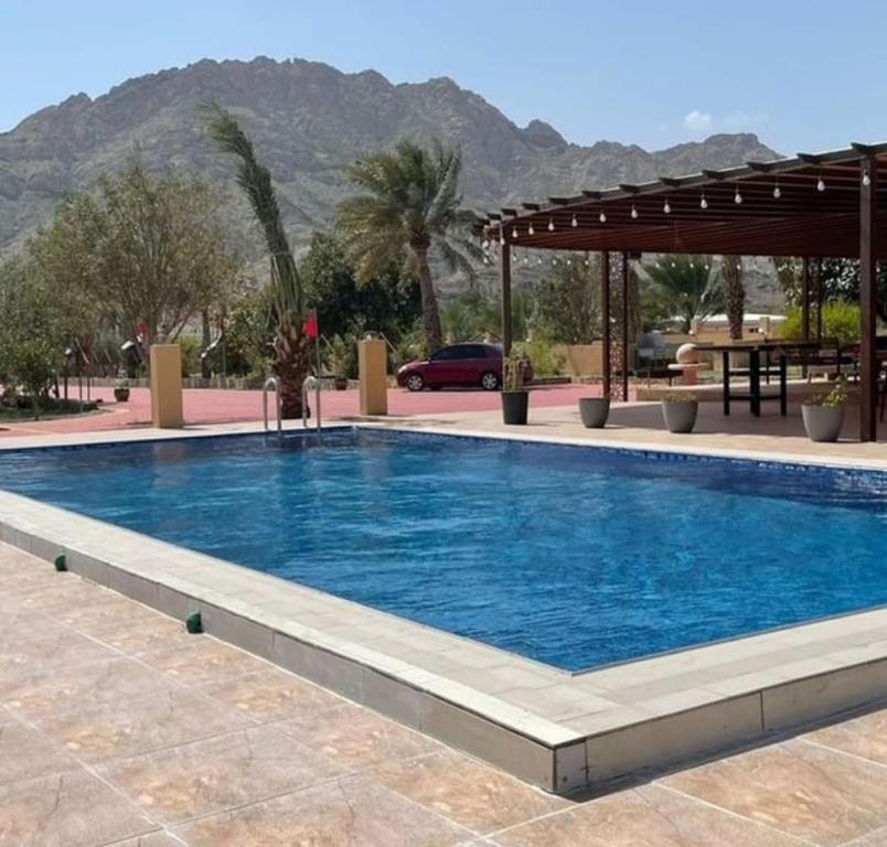 a swimming pool in a resort with mountains in the background at Oxygen hatta in Hatta