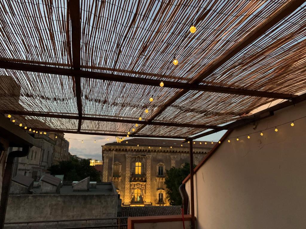 tenda da sole su un balcone con un edificio sullo sfondo di Teatro Greco Suite a Catania
