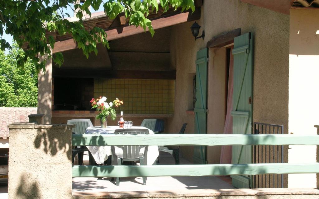une table et des chaises devant un bâtiment dans l'établissement L' erable aux esperifes, à Vidauban