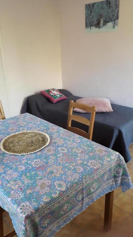 Cette chambre comprend une table, un lit et une chaise. dans l'établissement Gite au calme la mignonne, à Grimaud