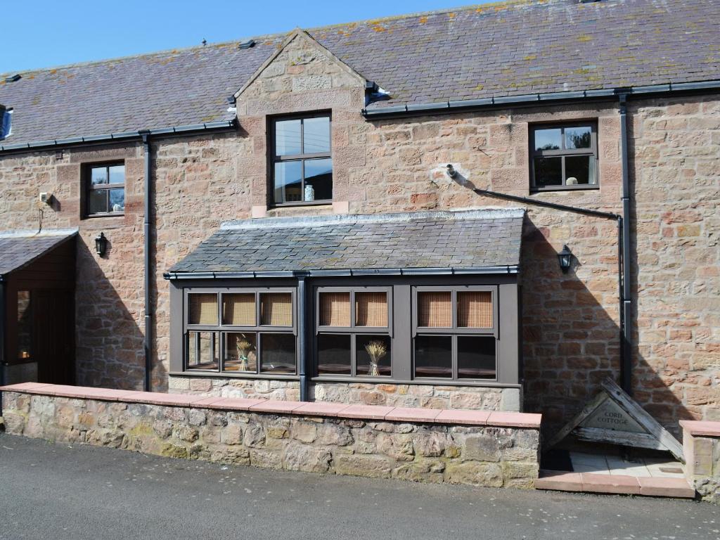 a brick building with windows on the side of it at Corn Cottage in Fenham