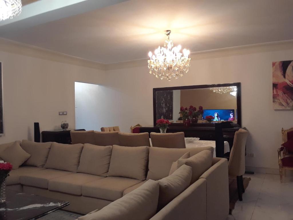 New Boutique Apartment Egypt في القاهرة: غرفة معيشة مع أريكة ومرآة كبيرة