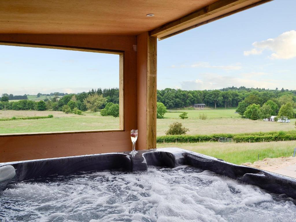 eine Whirlpool-Badewanne in einem Zimmer mit großem Fenster in der Unterkunft Dolview in Penybont