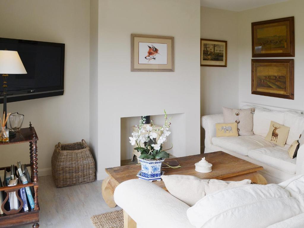 a living room with two white couches and a coffee table at Snooty Fox Cottage in Hexham