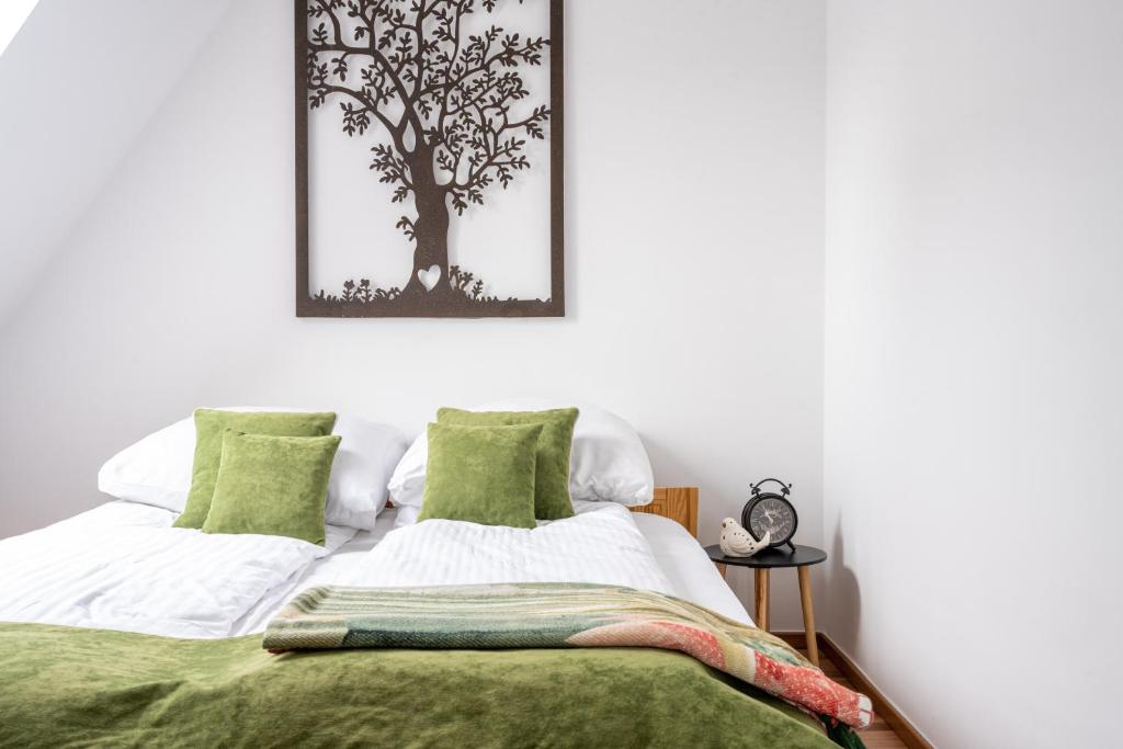 a bedroom with a bed with a tree picture on the wall at Apartamenty Rodzinne II ApartZakop in Zakopane