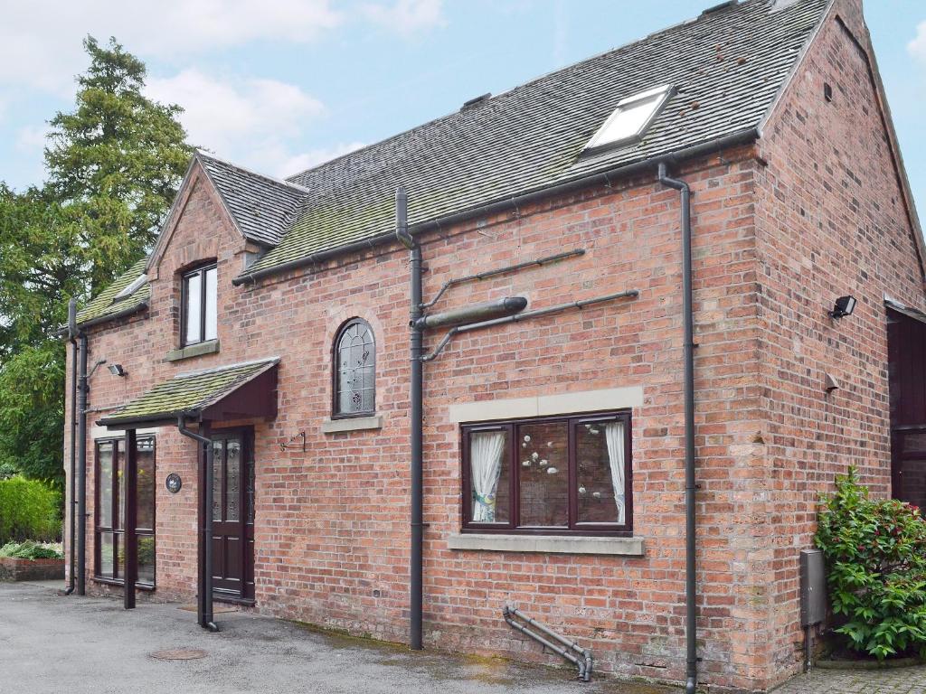 un antiguo edificio de ladrillo rojo con ventana en The Coach House en Swanwick