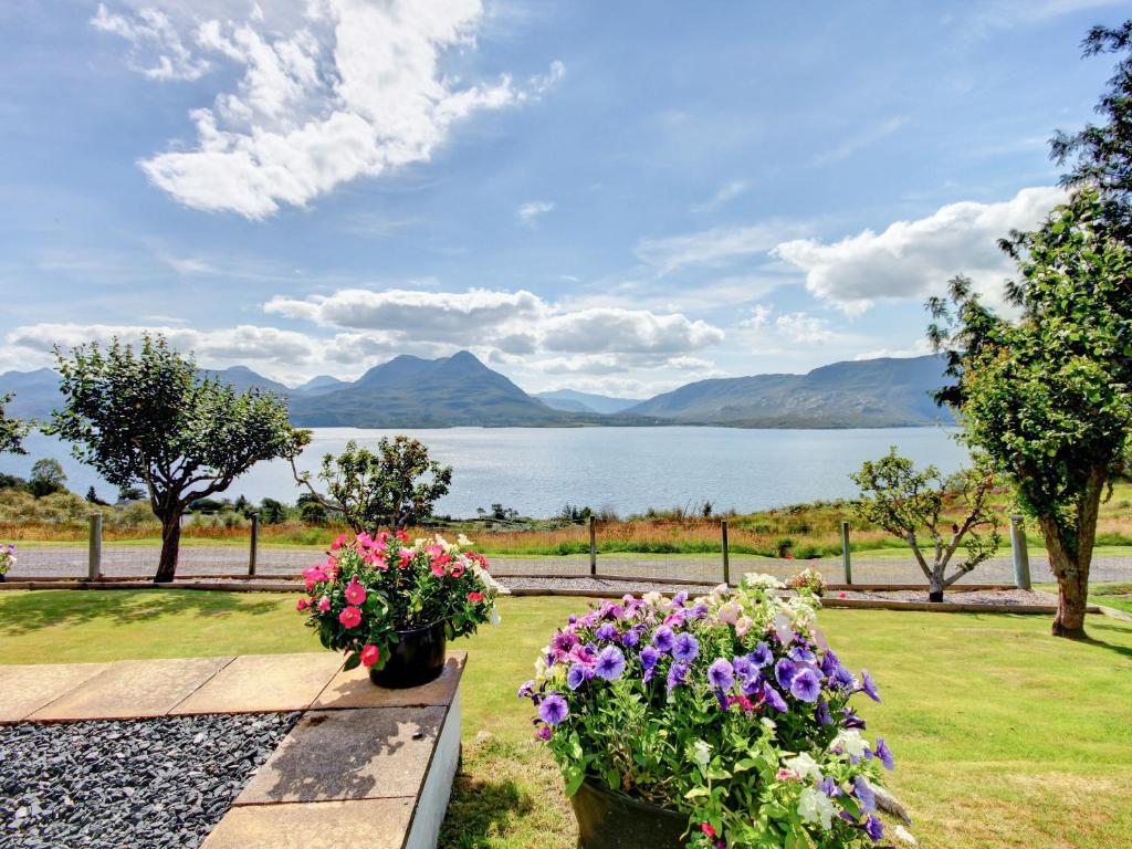 a garden with flowers and a view of a lake at Clachan in Torridon