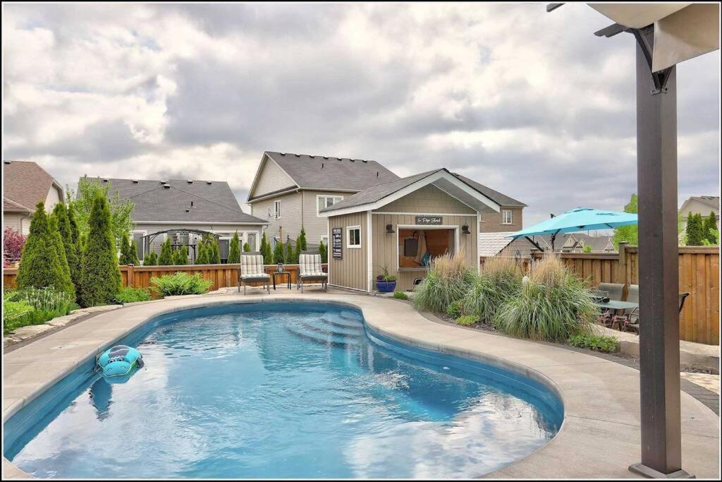 a swimming pool in front of a house at Living the Dream with Inground Heated Pool, Hot Tub, & Beach in Cobourg