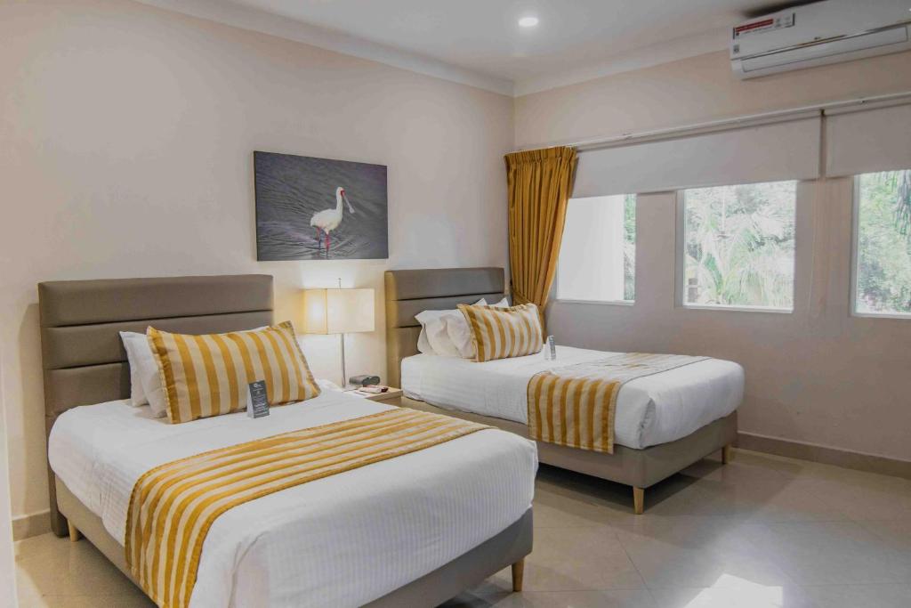 a hotel room with two beds and a window at Hotel Neiva Plaza in Neiva