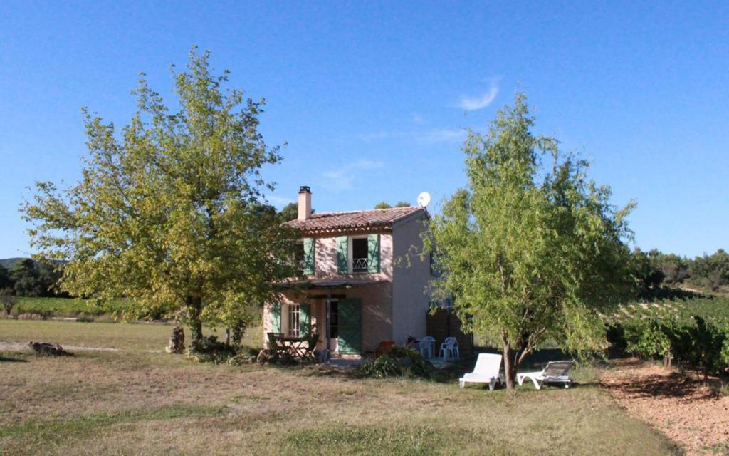 une petite maison dans un champ avec deux arbres dans l'établissement domaine de la creche, à Nans-les-Pins