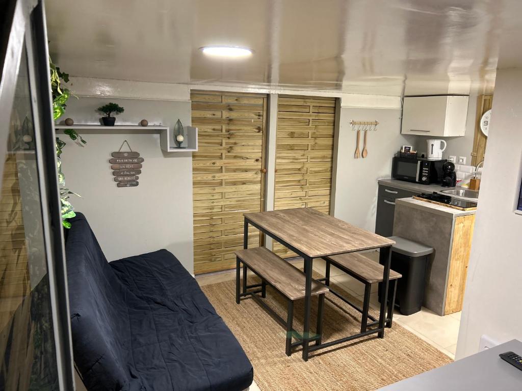 eine kleine Küche mit einem Tisch und einer Couch in einem Wohnwagen in der Unterkunft Appartement 2 chambres in Brignoles