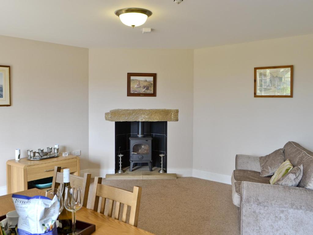 a living room with a couch and a fireplace at Plover Cottage in Sharperton