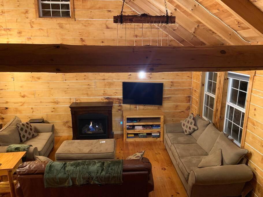a living room with a couch and a fireplace at Cozy Creekside Cabin in the heart of Hocking Hills in Laurelville