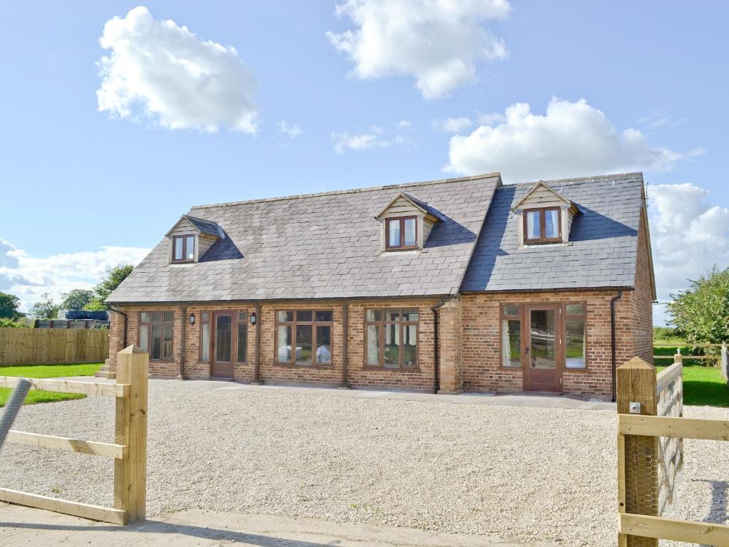 una casa con una valla de madera delante de ella en The Granary, en Tytherton Lucas